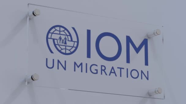 Логотип Международной Организации Миграции Iom Стеклянной Плите Матте — стоковое видео