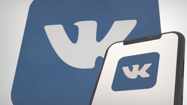 モバイルディスプレイ画面とバックグラウンドエディタのVk Vkontakteアプリのロゴ — ストック動画