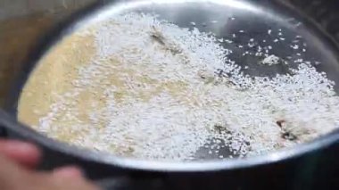 Amaranth tohumları pişiriliyor ve patlamış mısır gibi metal bir tencerenin içine atılıyor.