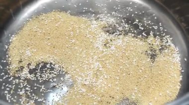 Amaranth tohumları pişiriliyor ve patlamış mısır gibi metal bir tencerenin içine atılıyor.