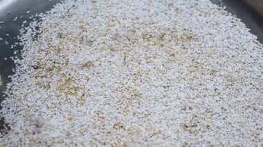 Amaranth tohumları pişiriliyor ve patlamış mısır gibi metal bir tencerenin içine atılıyor.