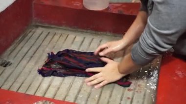 Guatemalalı bir kadın evdeki geleneksel su tankında çamaşır yıkıyor.