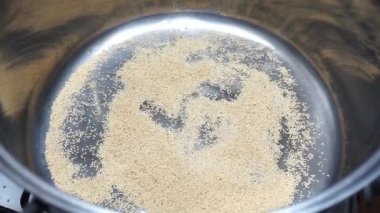 Amaranth tohumları pişiriliyor ve patlamış mısır gibi metal bir tencerenin içine atılıyor.