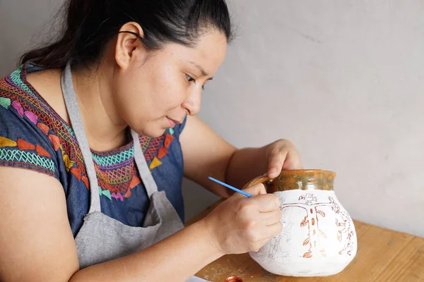 危地马拉妇女穿着传统的Huipil服装画在泥壶上 — 图库照片