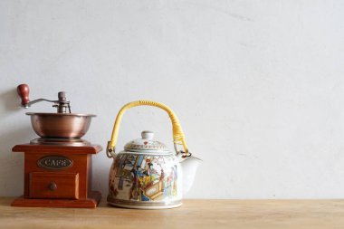 Klasik el yapımı kahve öğütücüsü ve seramik geleneksel Çin çay demliği, kahve ve çay karşılaştırması.