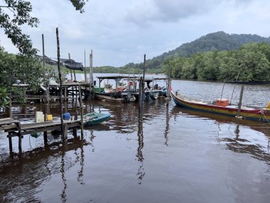 Kerteh, Terengganu, Malezya - 22 Aralık 2023: Muson mevsiminde akşam vakti küçük iskelenin manzarası balıkçıların denize açılmasına engel oluyor.