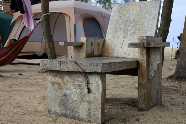 Bir glamping parkındaki çadırın önünde rahat bir hava yakalayan kırsal ahşap bir sandalye. Lüks kamp, açık hava eğlencesi ya da kırsal tatil ayarları için mükemmel..