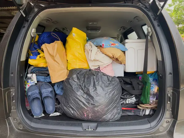 Terengganu, Malezya - 3 Haziran 2024: Renkli çantalar, yastıklar ve seyahat gereksinimleriyle dolu bir minivanın arkası.