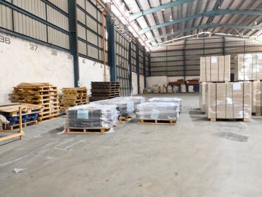 Perak, Malezya - 31 Temmuz 2025: İstiflenmiş ahşap paletler ve küçültülmüş paketler içeren organize depo.