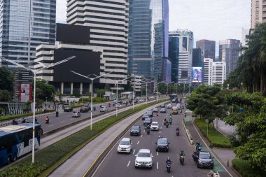 Sudirman 'da hafta içi sabahları trafik durgun olur. Arkaplanda ofis binası ya da gökdelenler