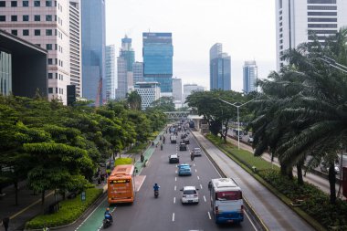 Sudirman 'da hafta içi sabahları trafik durgun olur. Arkaplanda ofis binası ya da gökdelenler