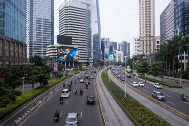 Sudirman 'da hafta içi sabahları trafik durgun olur. Arkaplanda ofis binası ya da gökdelenler