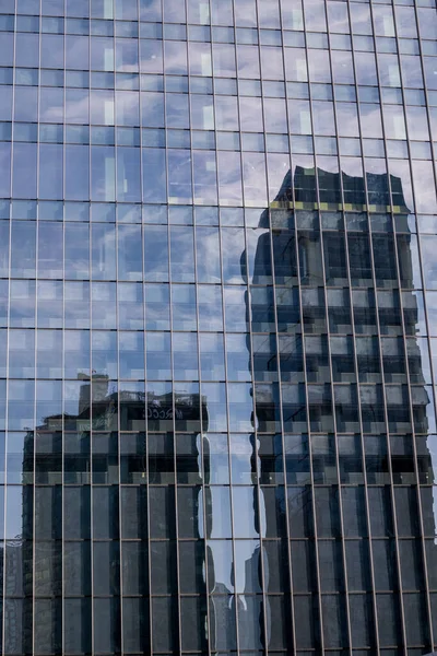 stock image View of a modern glass skyscraper reflecting the buildings around