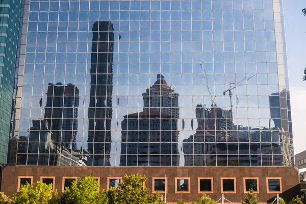 反映周围建筑物的现代玻璃摩天大楼的景观 — 图库照片