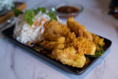 Singkong Goreng ya da Deep Fried Cassava, Endonezya 'nın geleneksel çerezidir. Sambal Roa ile ahşap tabakta servis edilir.
