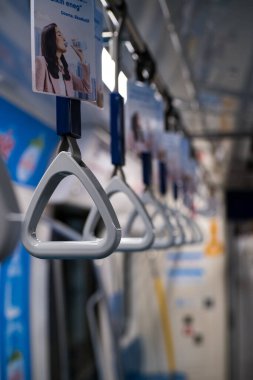 Bir metro treninin gri el ele tutuşunun yakın çekimi.