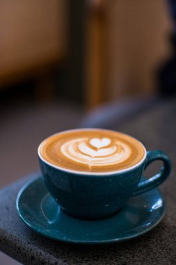 Cappuccino kahvesi masadaki güzel yeşil bardakta. Favori kahve konsepti.