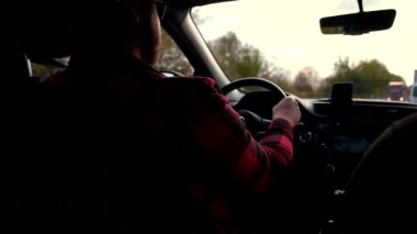 Sonbahar yollarında, bir adam arabasını sonbahar sezonunda sürüyor.