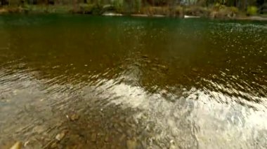 Sonbahar dağlarında kayalık nehir kıyısında yürüyen ilk insanın görüntüsü.