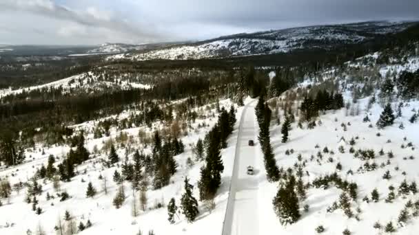 スロヴァキアの山岳地帯の雪道を移動する車の空中ビュー — ストック動画