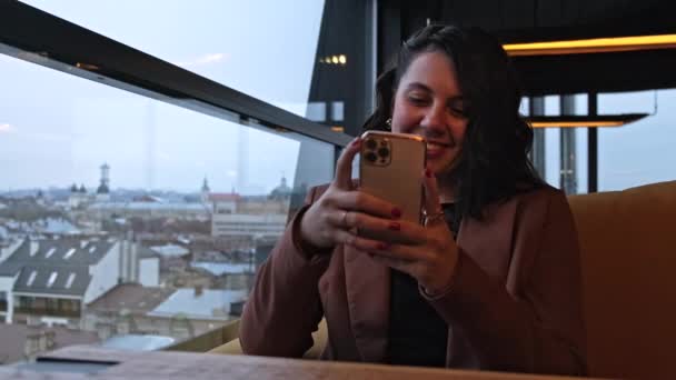 Glimlachende Vrouw Zitten Cafe Het Controleren Van Nieuws Telefoon — Stockvideo