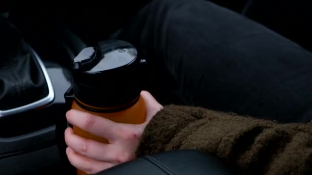 一个女人从汽车上拿起一个水瓶来保持水合 — 图库视频影像