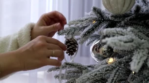 女人的手装饰着家的圣诞树 白色的枝条上覆盖着雪 — 图库视频影像