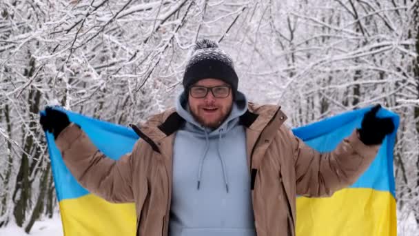 Retrato Del Hombre Sonriente Cubriendo Con Bandera Ucraniana Bosque Nevado — Vídeo de stock