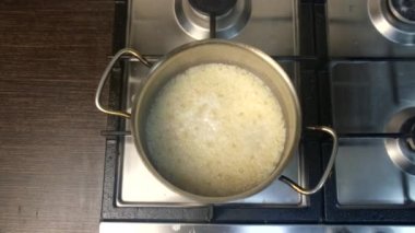 overhead view of cooking rice in pot steam from boiling water