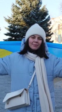 Noel zamanı Lviv şehir merkezinde Ukrayna bayrağıyla kaplanmış bir kadın.