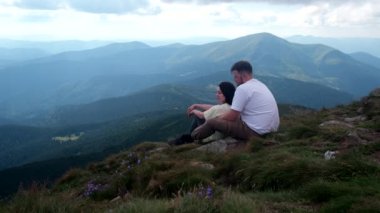 Ukrayna 'da Hoverla Dağı' nın tepesinde dinlenen çift yürüyüşçüleri