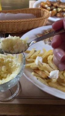 Lokantadaki kadının yemek yediği tabakları kapatın. Patates makinesi yiyor.