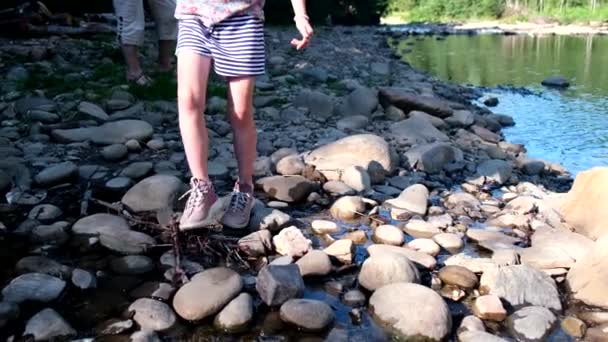 少女は山の川のビーチで岩のそばを歩く顔のない体の部分作物を閉じる — ストック動画