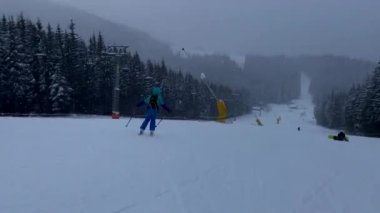 Dağlarda kayak yapan kadın kış tatili manzaralı.