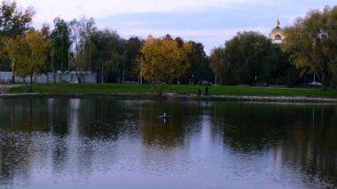 autumn evening city park with lake at autumn day panoramic view