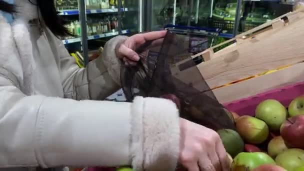 Жінка Вибирає Яблука Продуктовому Магазині Кладе Його Сумку — стокове відео