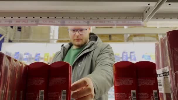 食料品店の男は店の棚から消臭ビューを選ぶ — ストック動画