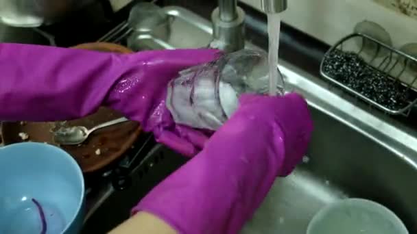 戴着橡胶手套的女人在厨房洗碗槽里洗碗 — 图库视频影像