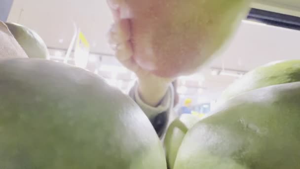 女性は食料品店の棚のコンセプトからマンゴーを取り — ストック動画
