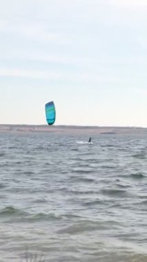 Kiteboardcu günbatımında rüzgarı kesiyor, rüzgarlı bir günde.