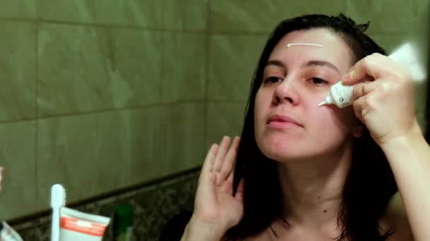 Mujer Cuidando Piel Usando Crema Después Ducha Frente Espejo — Vídeos de Stock