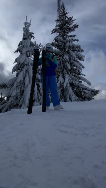 女性スキーヤーは冬のスポーツをスキーする準備ができて斜面にスキーを投げる — ストック動画