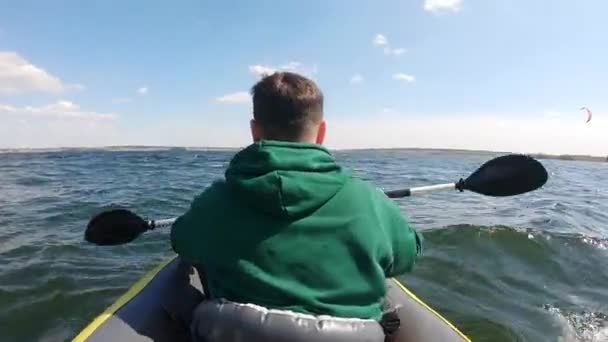 从后面看男子划桨在皮划艇风筝冲浪者背景 — 图库视频影像
