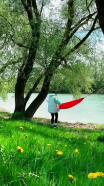 Nehir kıyısındaki hamakta dinlenen mutlu kadın fotokopi alanı