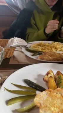 Lokantadaki kadının yemek yediği tabakları kapatın. Patates makinesi yiyor.