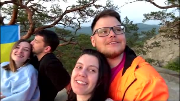 幸せな友達が崖の上に座って日没の自撮りを見て — ストック動画