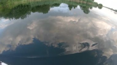 Sakin göl gölünde yüzen kadın bacakları su bulutlarının yansıması