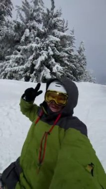 Mutlu snowboardcu, kar altında selfie konuşuyor.
