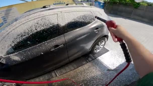 Mann Wäscht Auto Bei Autowaschanlage Mit Hochdruckwasser — Stockvideo