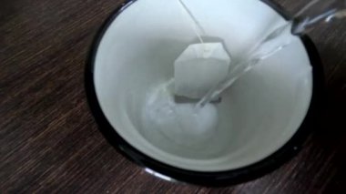 Çay yapıp bardağa su döküyorum.